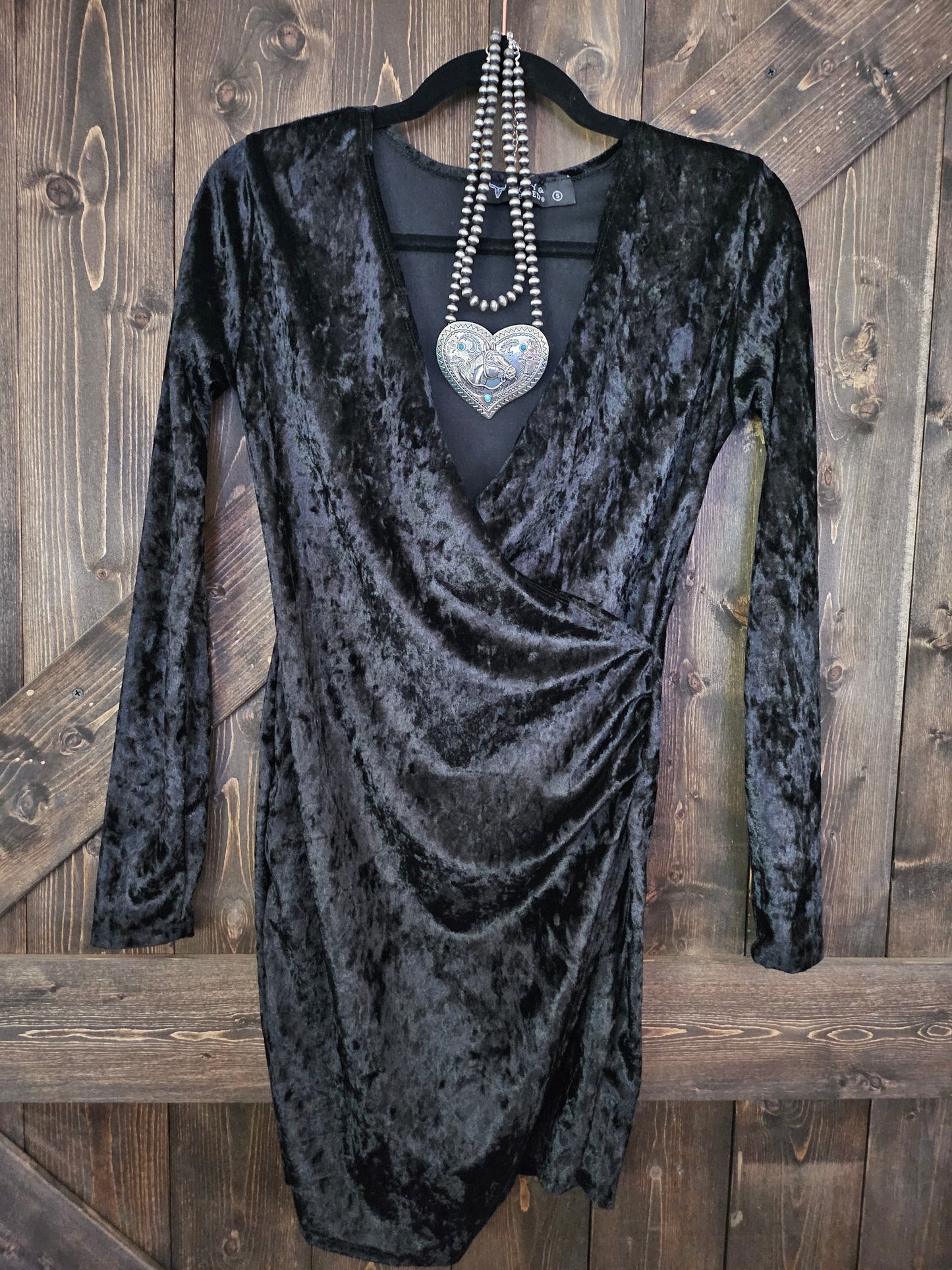 Black velvet body-con wrap dress with long sleeve and v neckline.