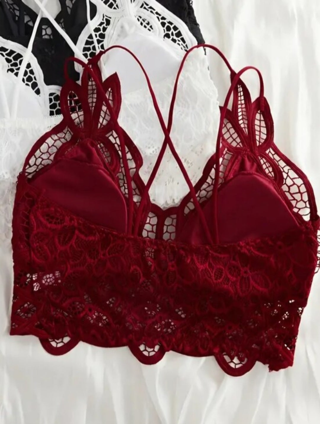 Red lace bralette with criss-cross straps and removable padding.