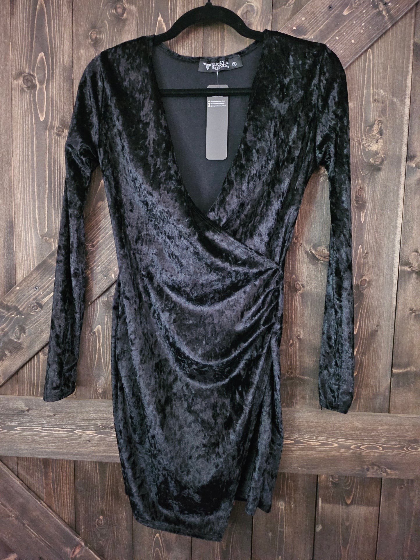 Black velvet body-con wrap dress with long sleeve and v neckline.