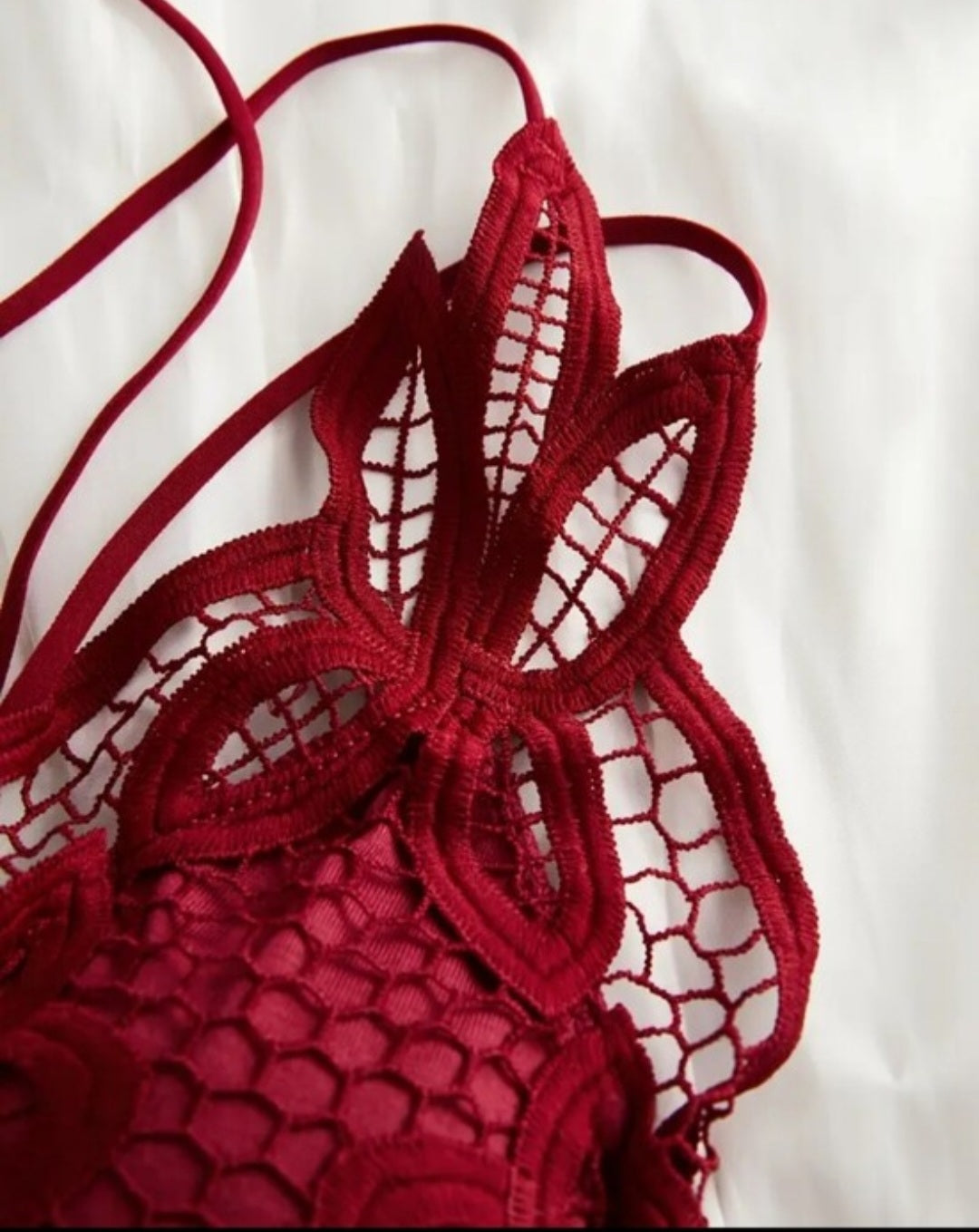 Red lace bralette with criss-cross straps and removable padding.