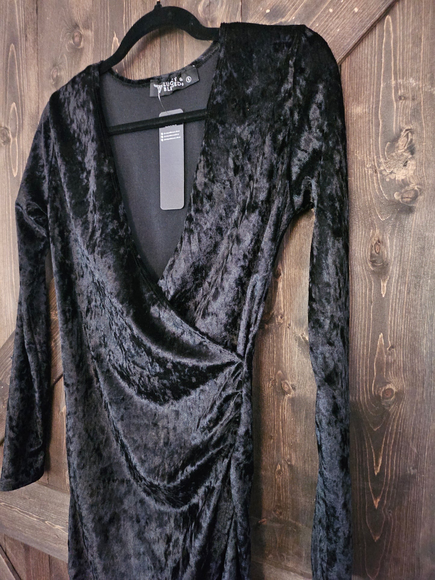 Black velvet body-con wrap dress with long sleeve and v neckline.