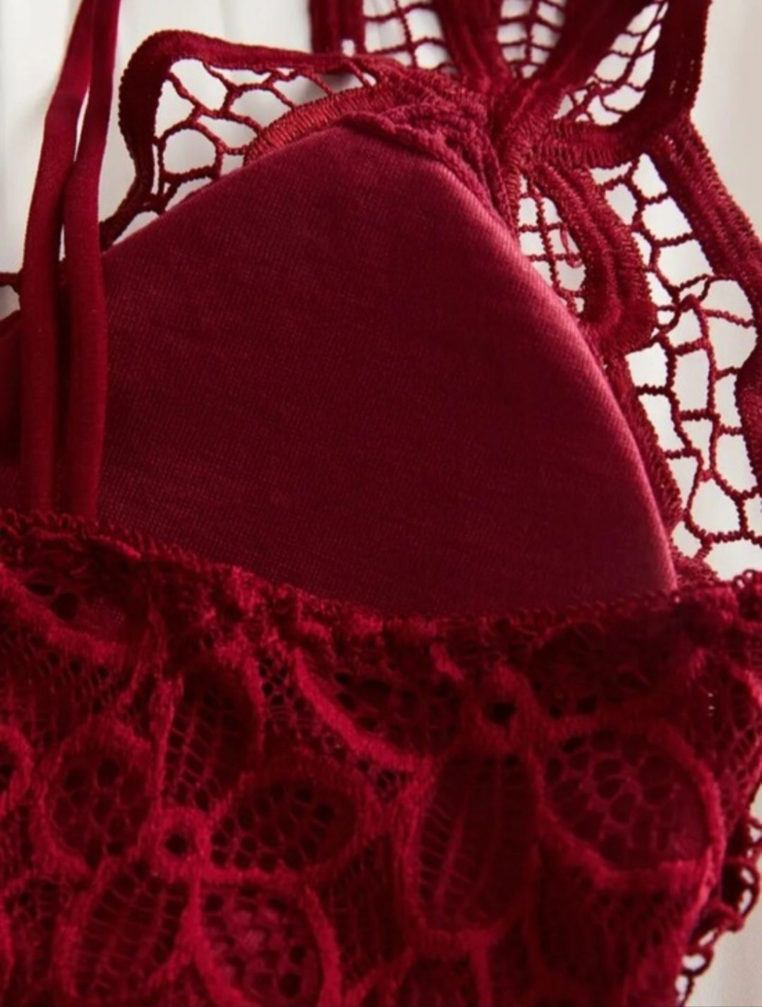 Red lace bralette with criss-cross straps and removable padding.