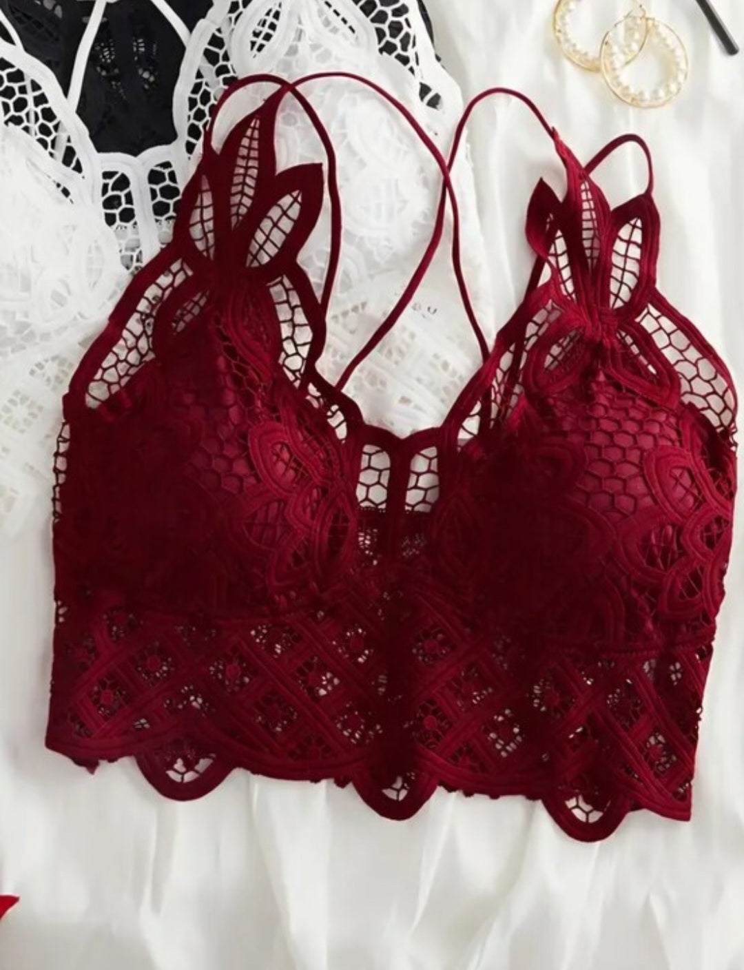 Red lace bralette with criss-cross straps and removable padding.