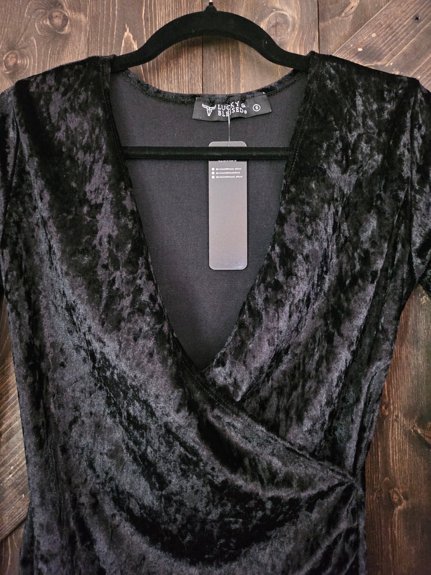 Black velvet body-con wrap dress with long sleeve and v neckline.