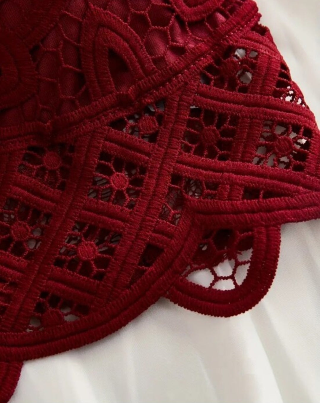 Red lace bralette with criss-cross straps and removable padding.